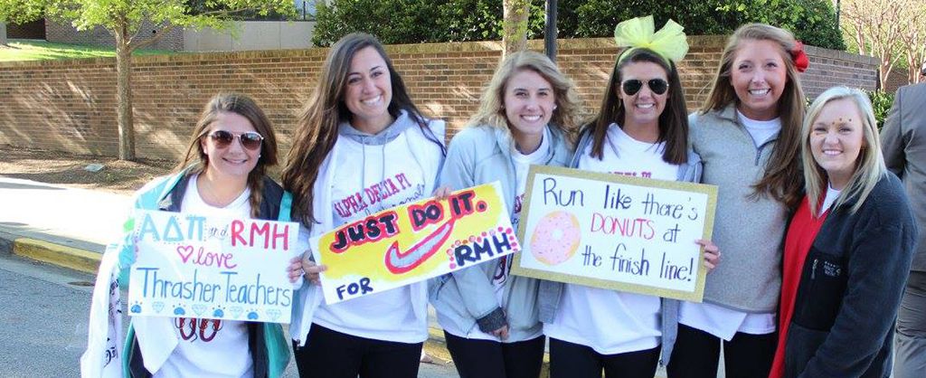 group of sorority sisters with handmade signs supporting RMHC greater chattanooga